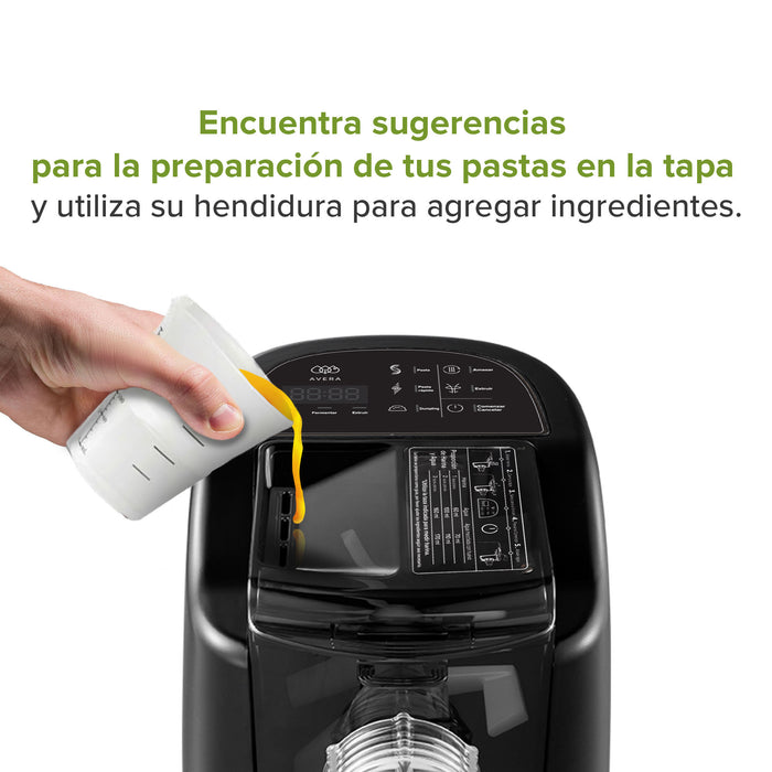 Persona vertiendo mezcla a través de la tapa de la máquina para hacer pasta.