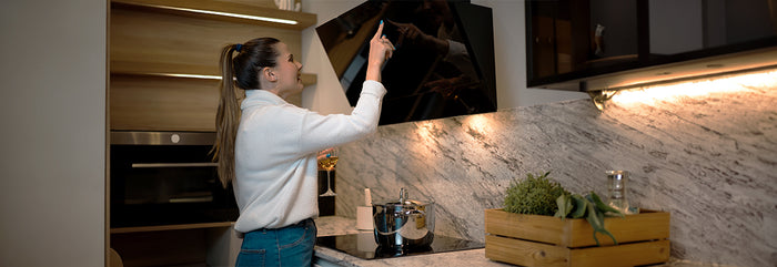 Mujer controlando una campana de cocina digital