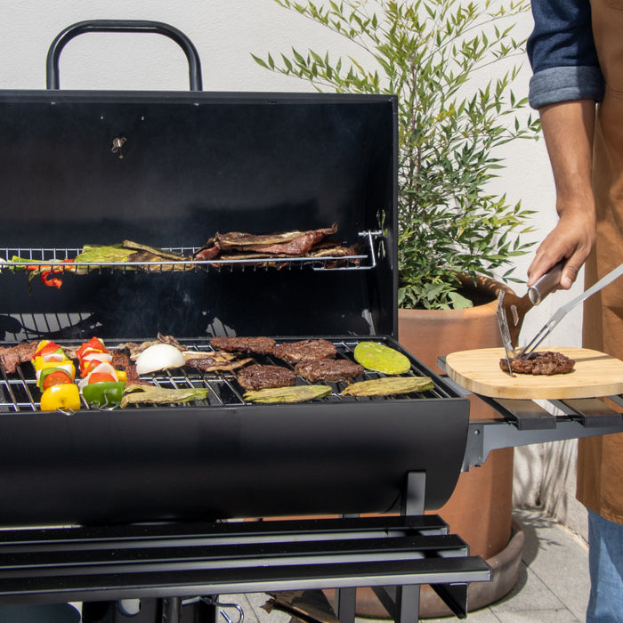 Persona preparando carne asada en un asador