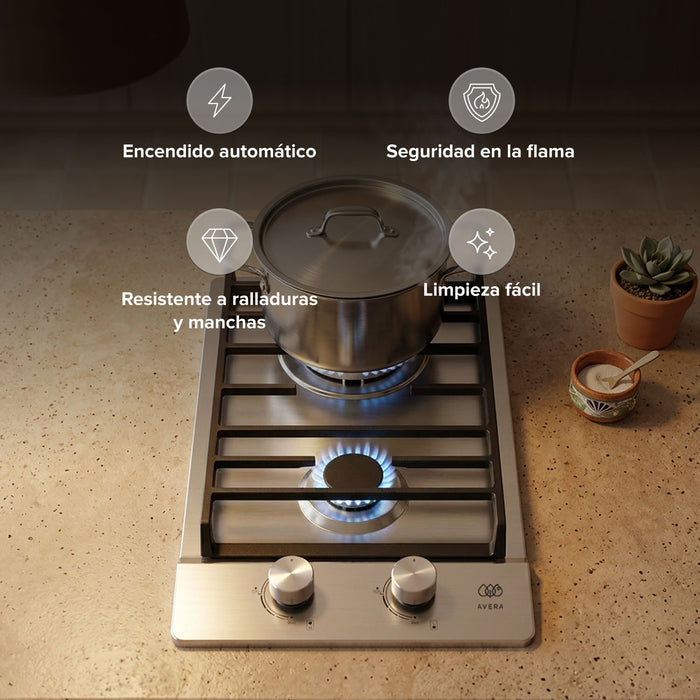 Parrilla de gas de 2 quemadores en acero inoxidable con encendido automático y olla sobre flama azul en cocina moderna.