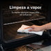 Mano limpiando interior de horno a gas natural Avera con función de limpieza a vapor y rejillas de acero.