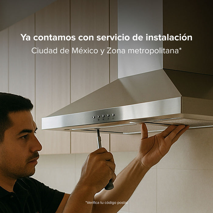 Técnico instalando campana extractora de pared de 90 cm en acero inoxidable en cocina moderna, servicio disponible en CDMX.